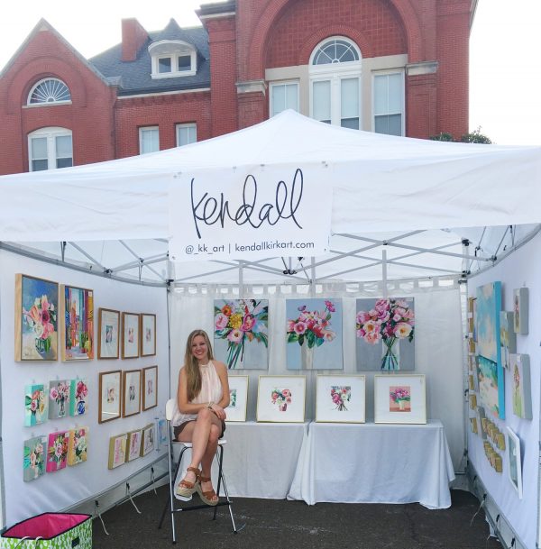 A minimalist booth that makes your art pop is a great way to attract customers at an art market. 